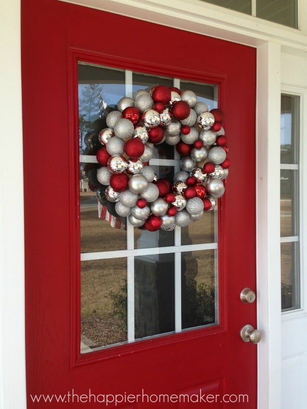Front porch lanterns with Christmas ornaments.