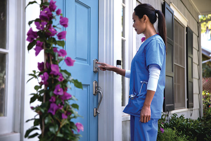 In-home nurse entering access code on Schlage Encode smart lock.