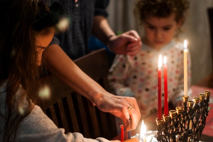 Family lighting the Hanukkah Menorah