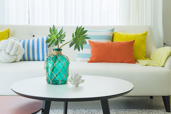 Modern coastal living room with blue, yellow and orange pillows.