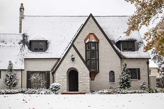 White tudor home with copper accents during winter.