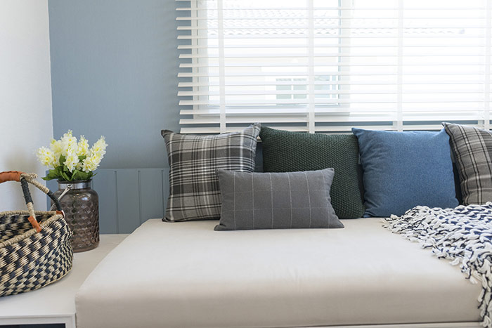 Window seat with blue, grey and green pillows