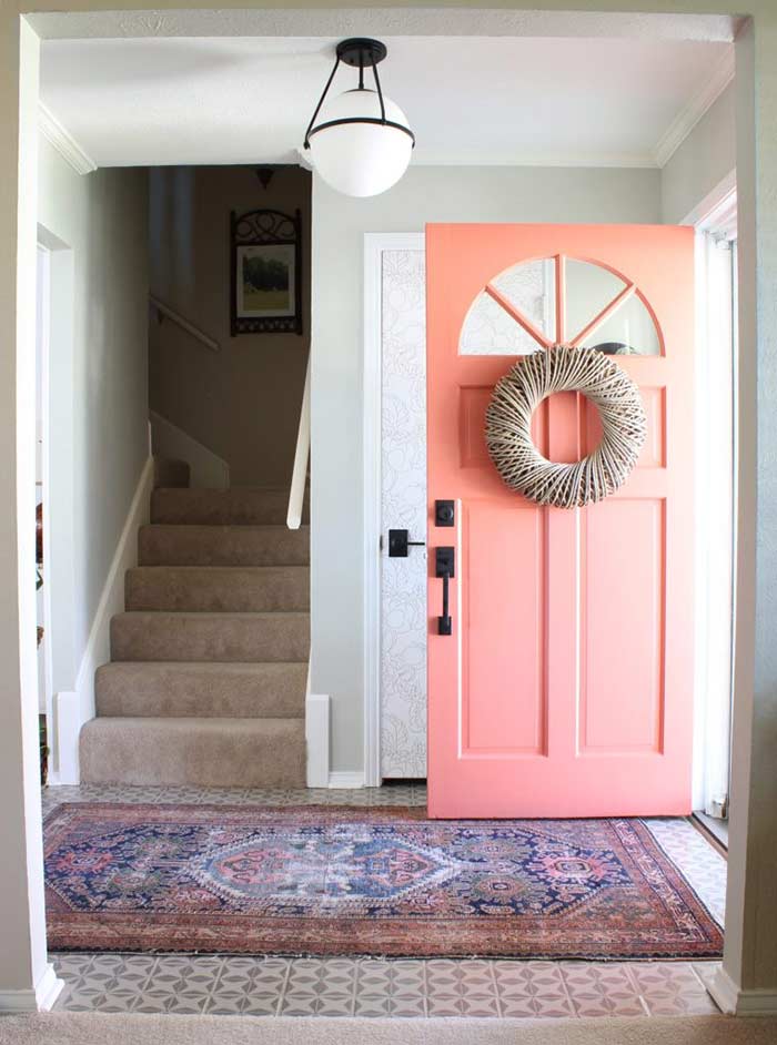 Entryway with coral front door and Matte Black Schlage locks.