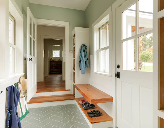 Farmhouse back entry with tile herringbone tile floors.