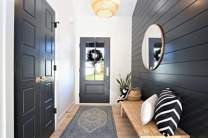 Scandinavian entryway with black shiplap wall.