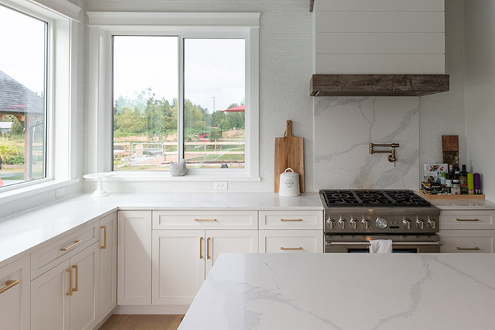 White farmhouse kitchen with brass hardware.