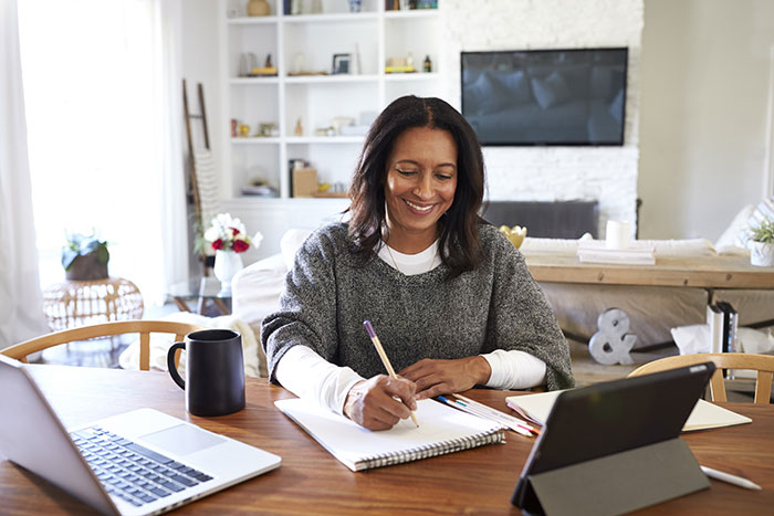 Woman sitting at dining room table planning future renovations.