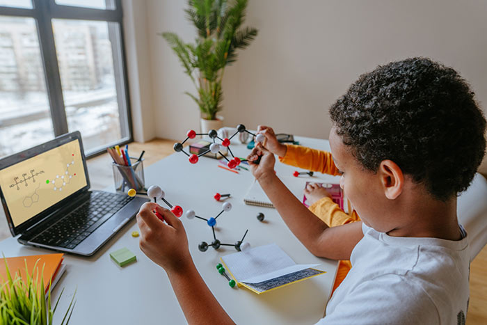 Boy sitting at table doing school work.