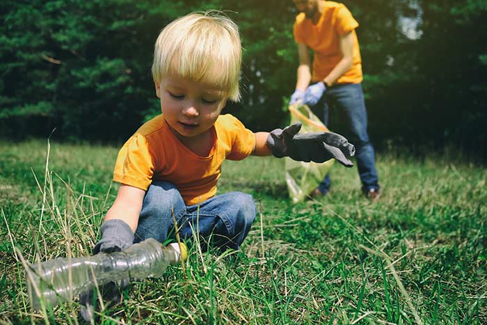 Toddler picking up litter.