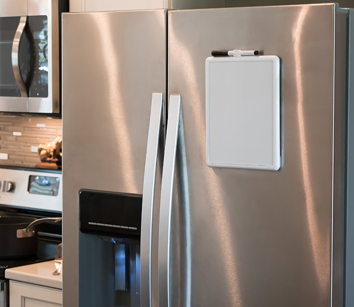 Dry erase board on stainless steel refrigerator.