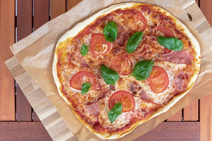 Homemade pizza with tomatoes and basil from the garden.