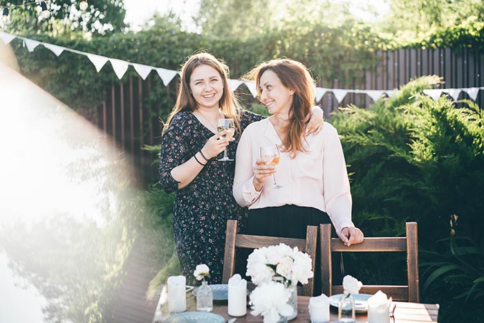 Mother and daughter embrace during backyard party.