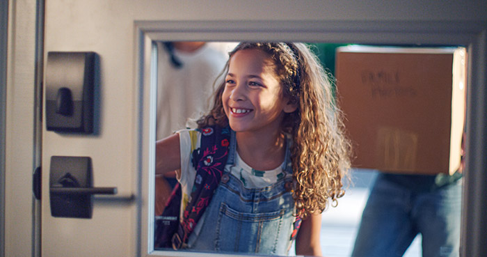 Young girl unlocking front door with Schlage Encode wifi smart lock.