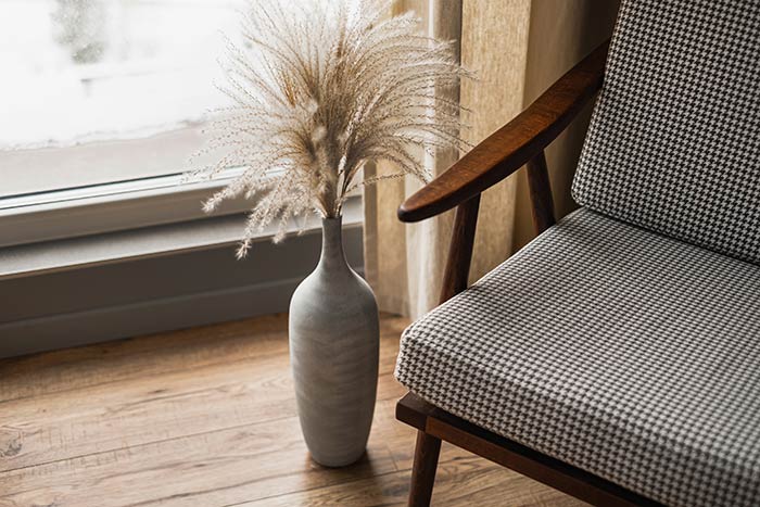 Mid-century modern chair next to pampas grass bouquet.