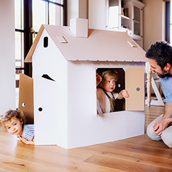 children and father playing with cardboard box.