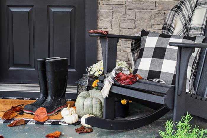 Black front porch rocker with buffalo plaid textiles.