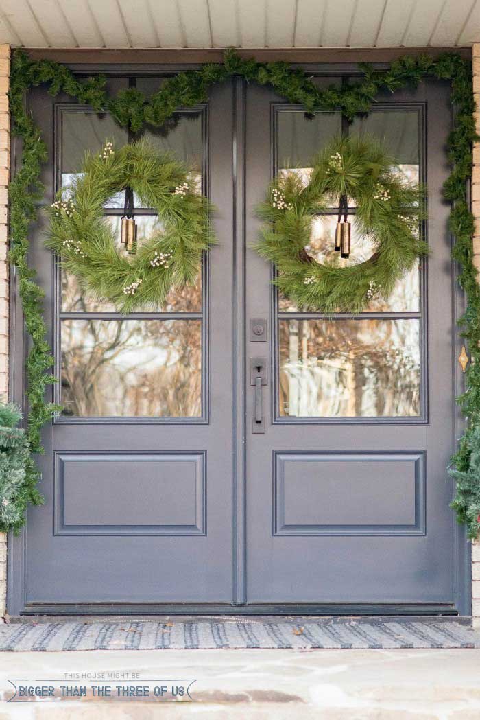 Exterior french doors decorated for Christmas with wreaths and garland.