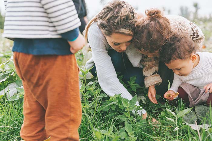 Mom and young children working in garden.