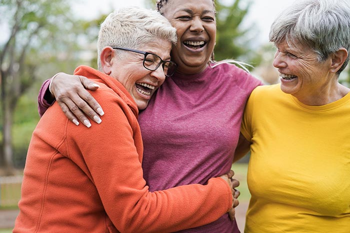 Three friends laughing and embracing.