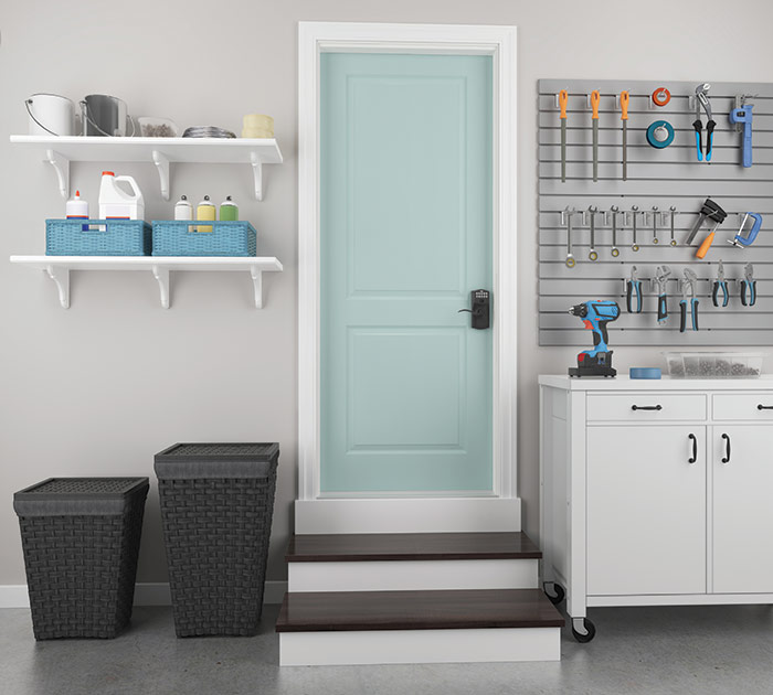 Organized garage with wall storage and Schlage keypad lever on blue door.