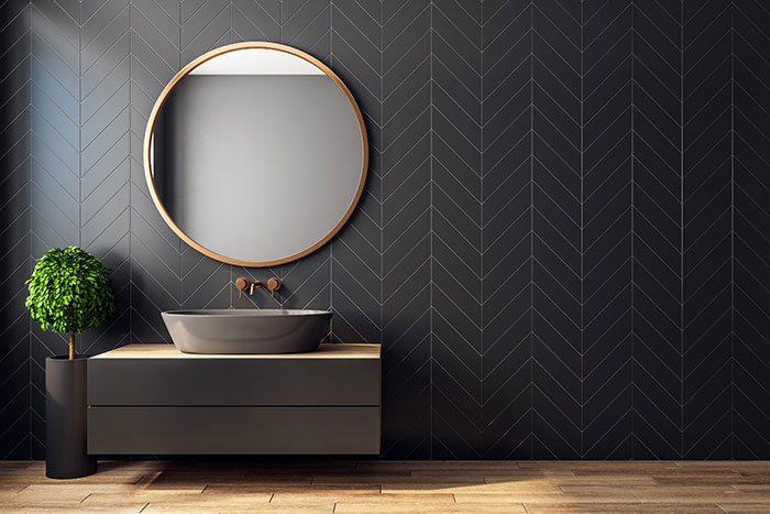 Bathroom with black tile wall and brass finishes.