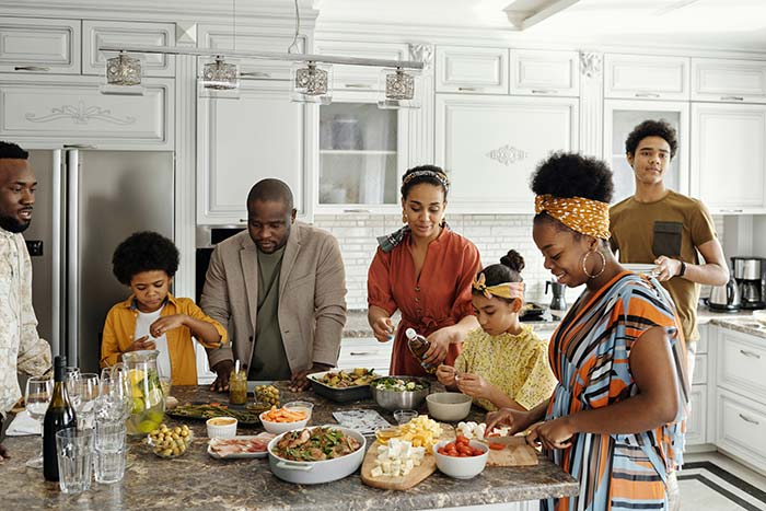 Family around kitchen island preparing holiday food for party.