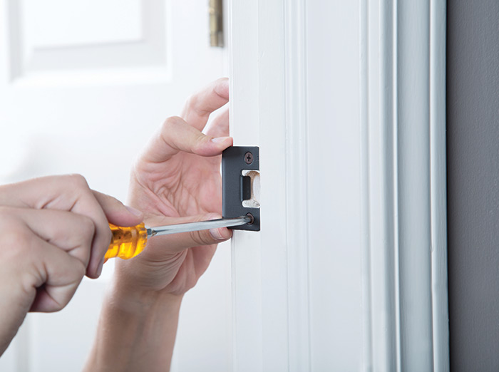 Installing door strike plate part of door lock.