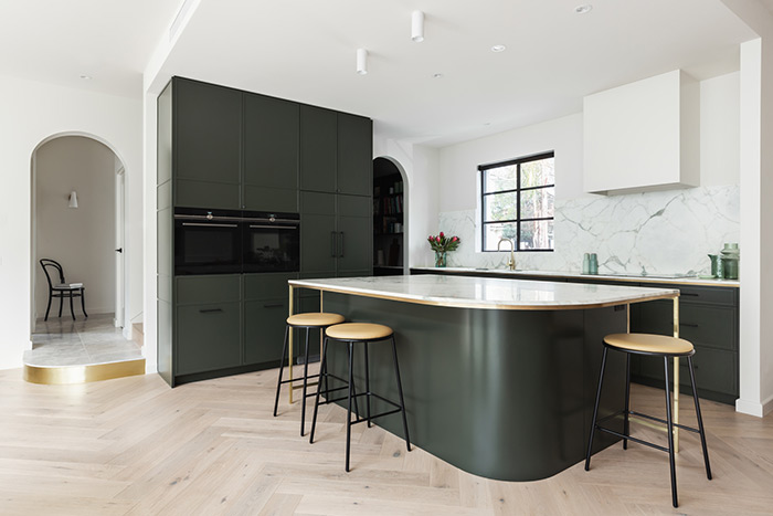 Modern kitchen with rounded island and arched doorways.