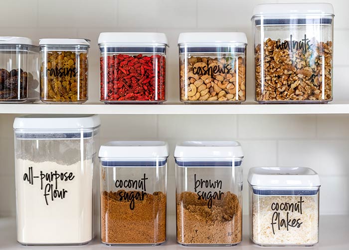 Pantry organization with labeled containers of baking items.