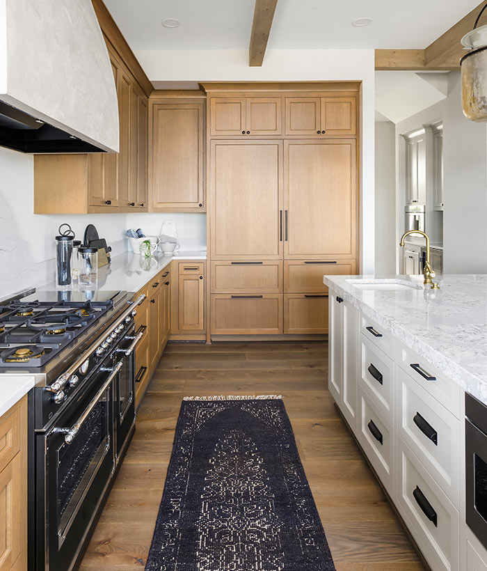 Kitchen with wood cabinets, white island and marble look quartz countertops