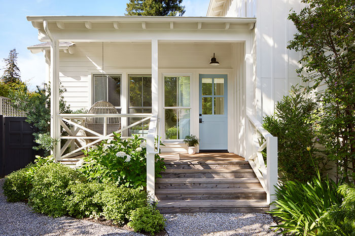 White bungalow modern farmhouse front porch ideas with coastal blue front door.