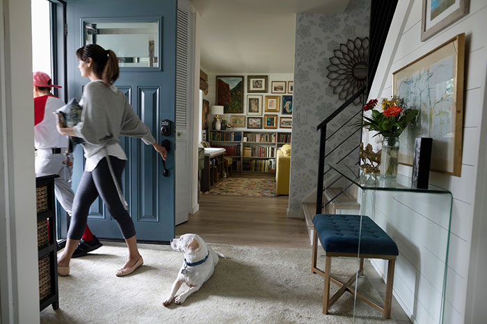 Family leaving foyer for baseball practice while dog watches.