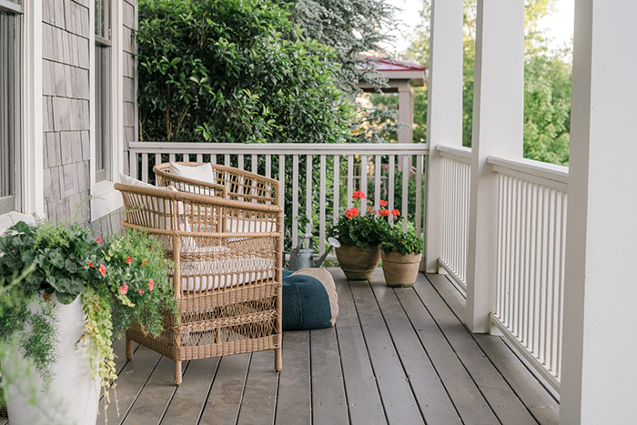 Southern front porch with cozy seats and planted flowers.