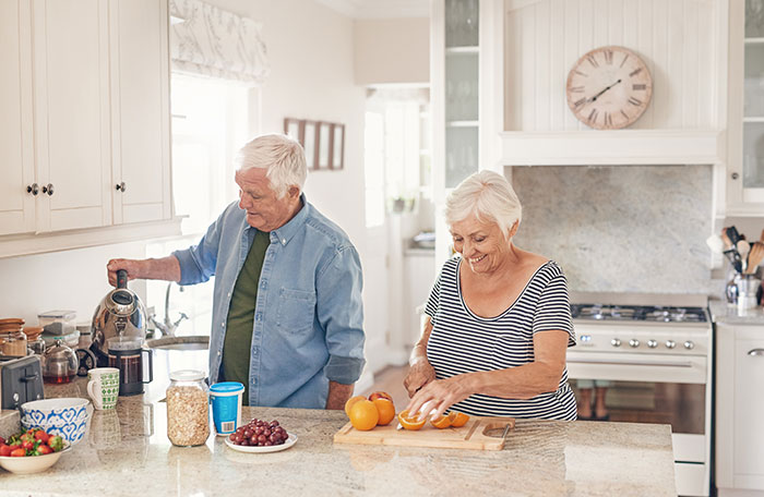 Happy couple in kitchen preparing breakfast together.