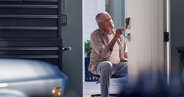 Man installing Schlage smart lock on garage door.