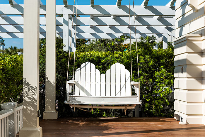 Porch swing with plant wall for privacy.