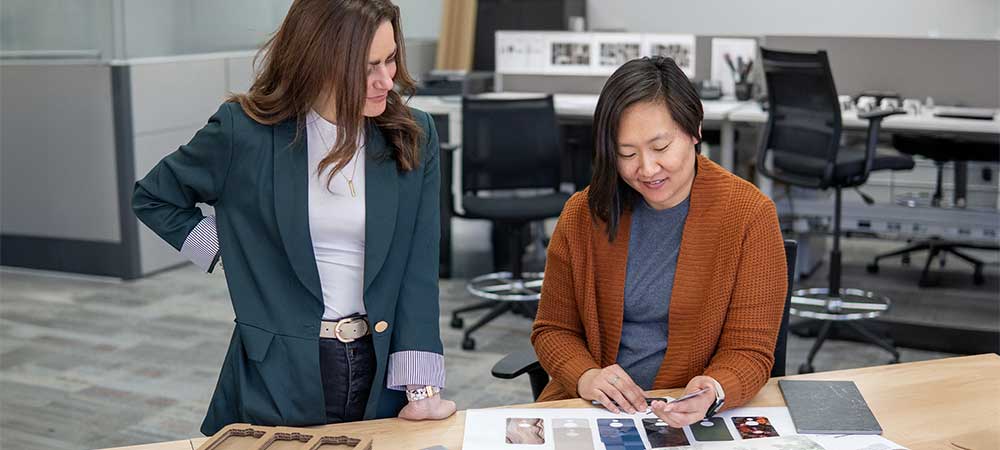 Members of the Pin and Tumbler Studio team gathered around product samples.