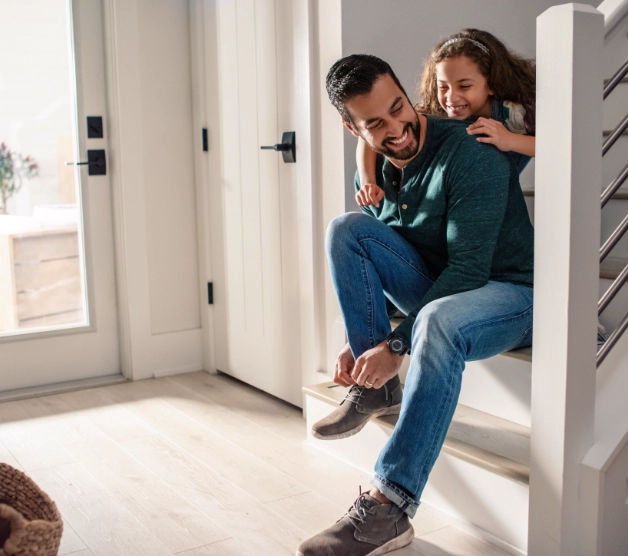 Father and daughter next to Schlage matte black door levers. 