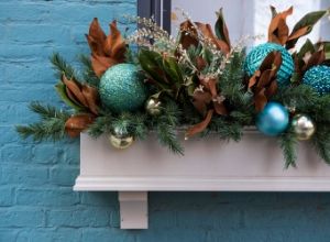 Flower box with holiday ornaments and Christmas greenery.