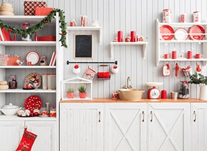 White farmhouse kitchen with red Christmas decorations.
