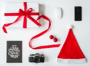 iPhone, apple mouse, camera, holiday package and santa hat.