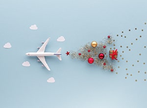 Airplane with stream of ornaments in shape of Christmas tree.