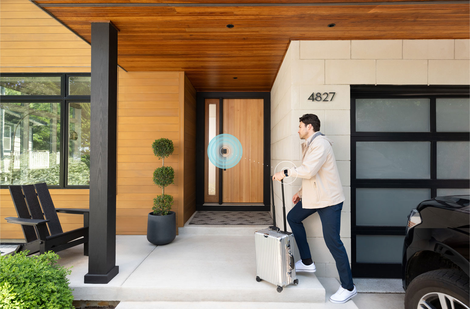 Man with suitcase walks through front door using Schlage Sense Pro Ultra-wideband smart lock to unlock door with Apple watch