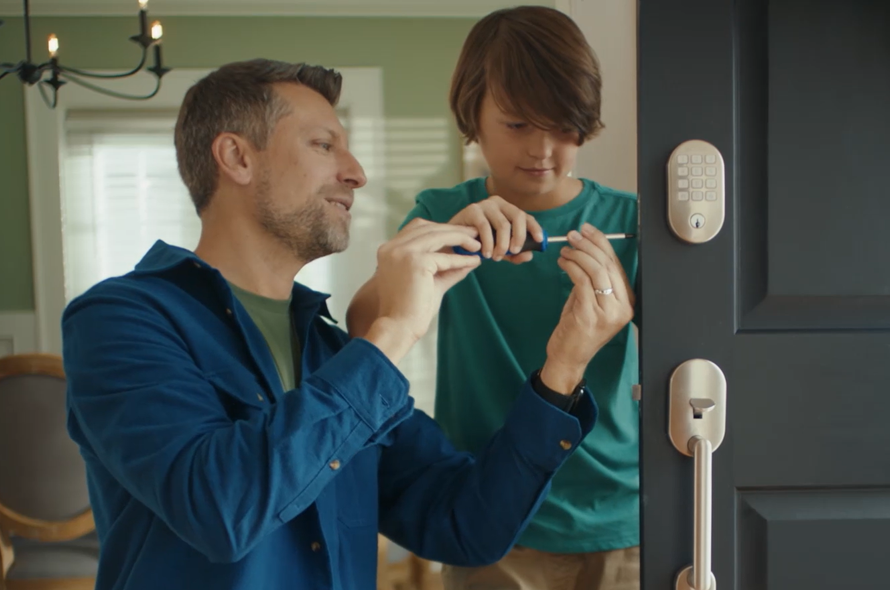 Father and child installing an Arrive smart lock.