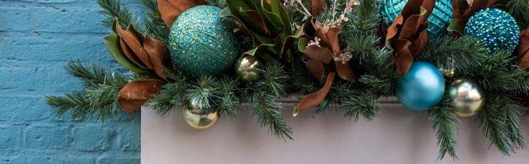 Flower box with holiday ornaments and Christmas greenery.