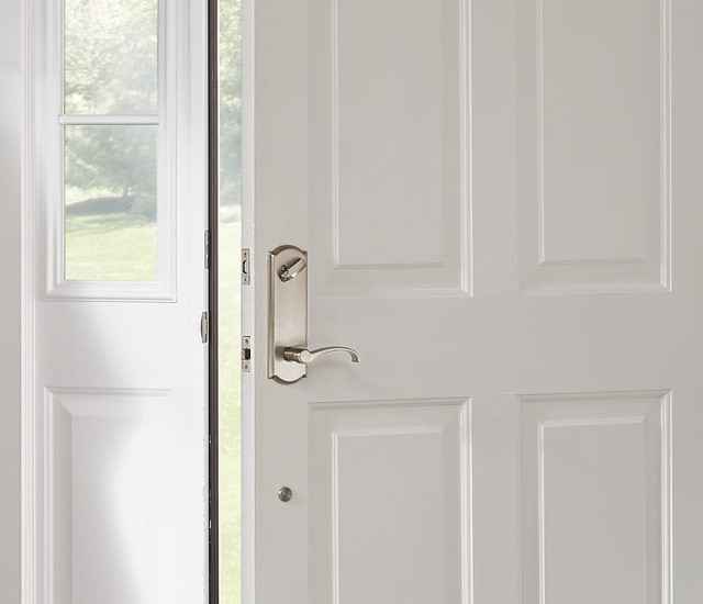 Schlage Whitney lever with Camelot trim in Satin Nickel on white front door.