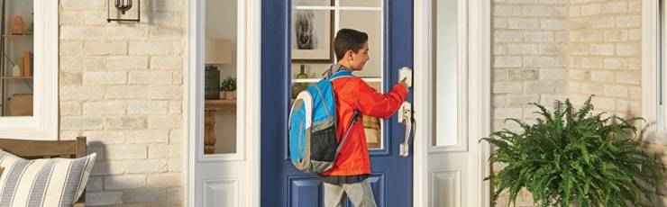 Boy with backpack using Schlage Encode smart lock.