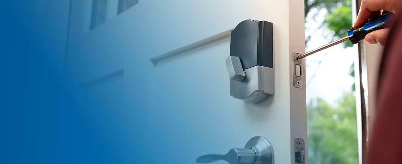 Person installing smart lock on front door with just a screw driver.