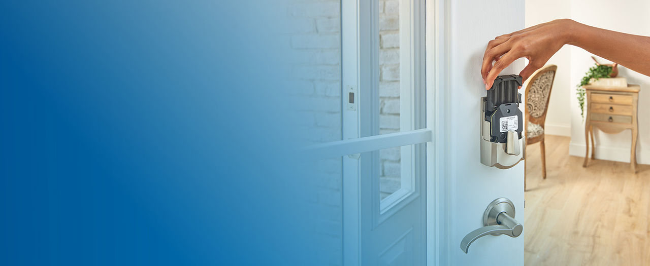 Person removing battery pack from Schlage Encode Smart Lock installed on open front door